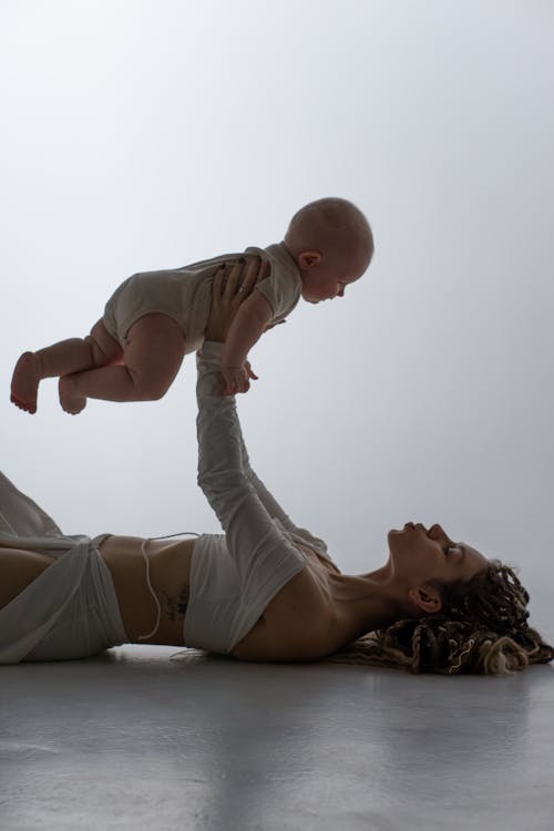 Free Woman Playing with a Baby on the Floor Stock Photo