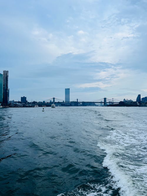 Sea and City Buildings behind Sailing Vessel