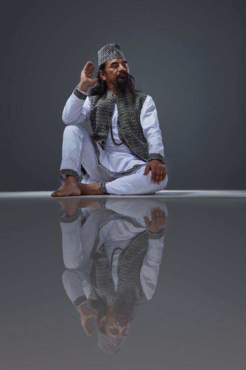 A man sitting on the floor with his hands up