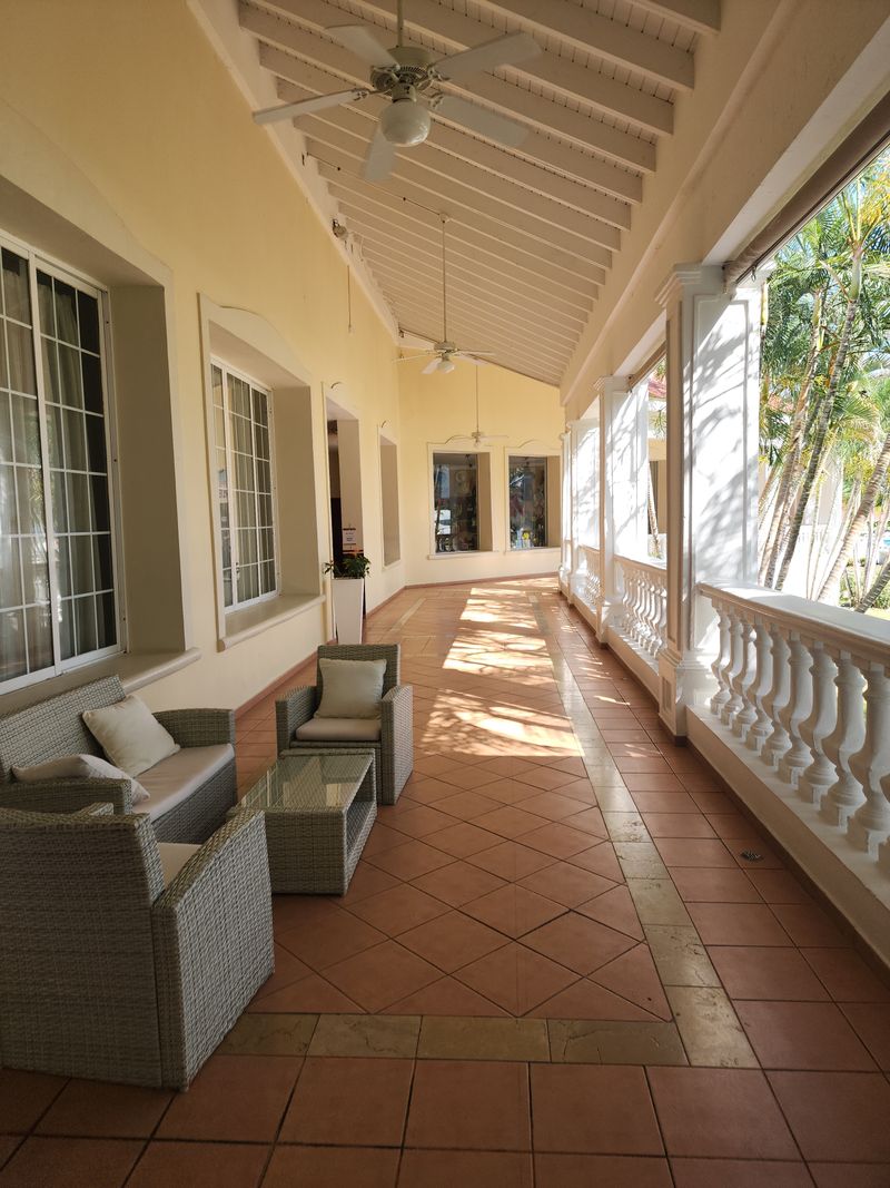 Terrace with table, sofa and armchairs on outdoor tiles