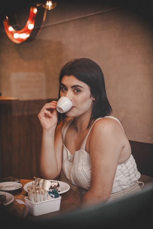 Free Young woman enjoying a cup of espresso in a cozy café setting in Santo André, Brazil. Stock Photo