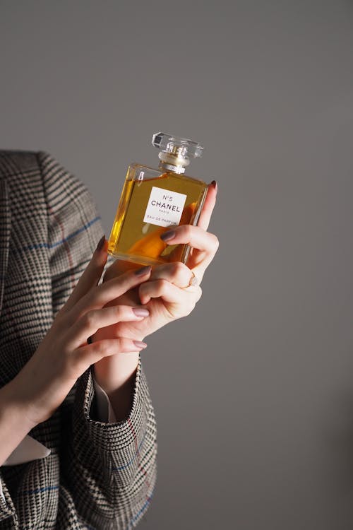 A woman holding a bottle of perfume