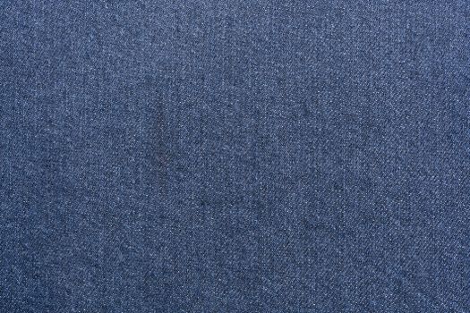 Detailed close-up of blue denim-like fabric texture with ample copy space.