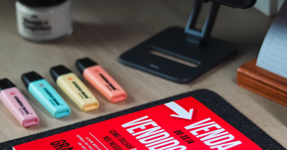 Mesa organizada com livro, tablet e teclado, representando estudo e organização financeira