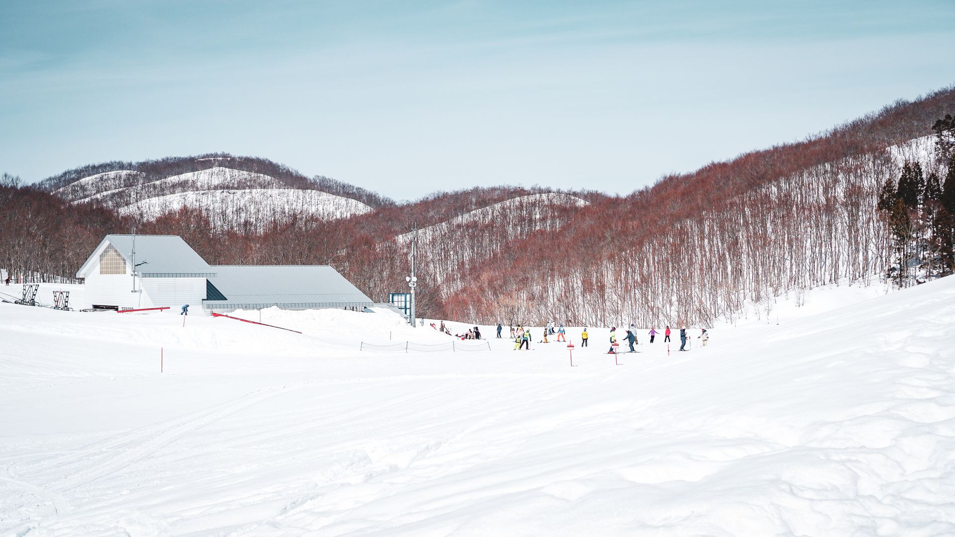Winter scene at Yuzawa ski resort in Japan with snow-covered slopes and skiers enjoying the day.