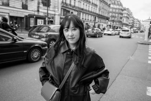 A woman in a black coat standing on a street