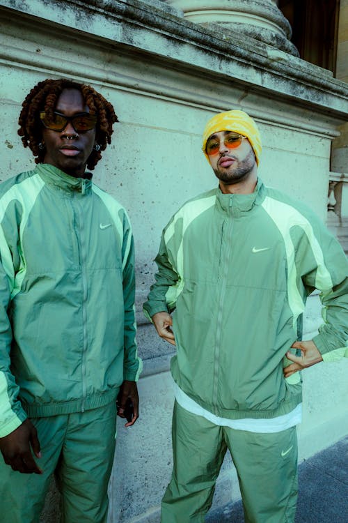 Two men in green tracksuits standing next to each other