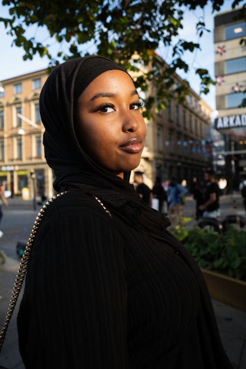 A woman in a black hijab standing in a city