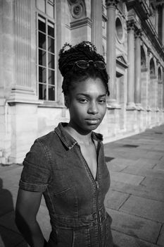 Black and white portrait of an African American woman standing in front of an urban building.