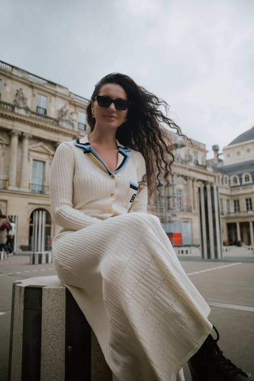 A woman in a white dress sitting on a bench