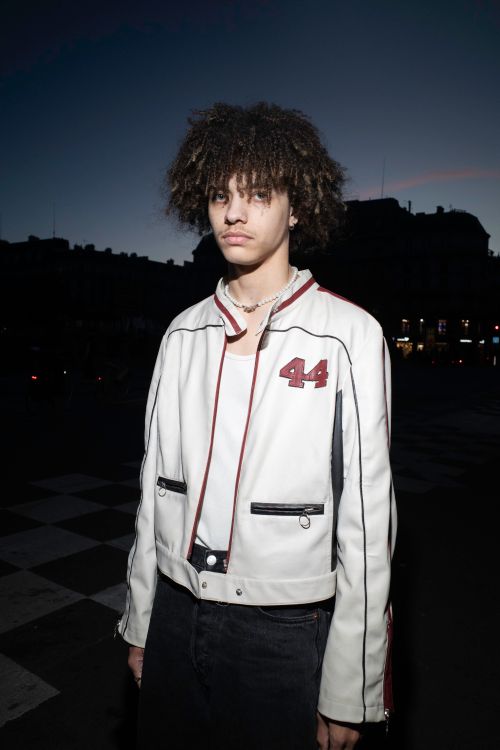 Free Portrait of a young man in a stylish jacket standing in a city at dusk, highlighting urban fashion. Stock Photo