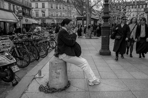 A woman sitting on a bench in the middle of a city