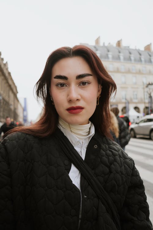 A woman with red hair and black jacket in paris