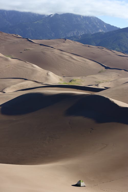 A tent is set up on the sand dunes