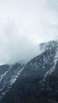 Scenic view of snow-covered mountains and clouds in Obergurgl, Tyrol, Austria, capturing the serene winter landscape.