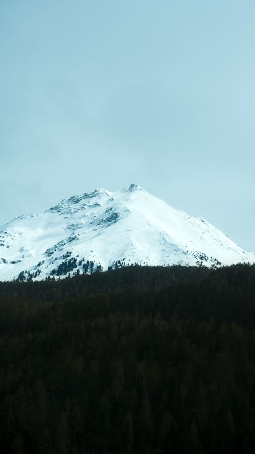 Free Stunning snow-covered peak in the Swiss Alps near Zürich, surrounded by dense forest. Stock Photo
