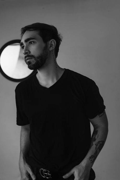 Free Stylish black and white portrait of a bearded man wearing a t-shirt, set against a minimalistic background. Stock Photo