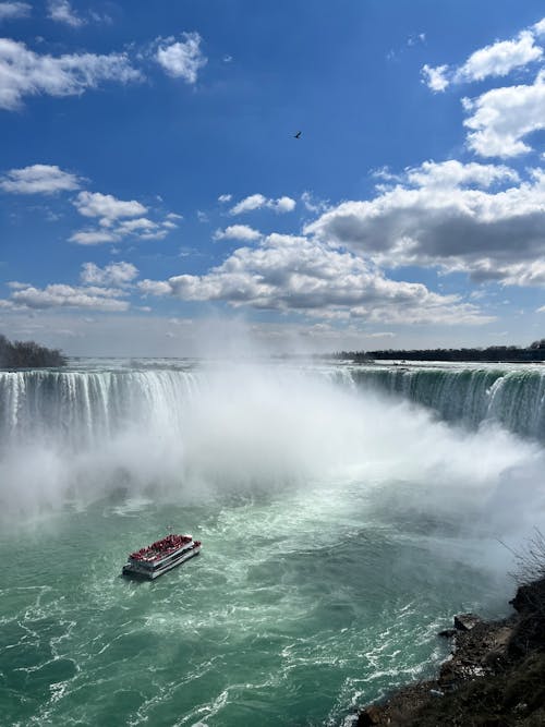 A boat is floating in the water near niagara falls