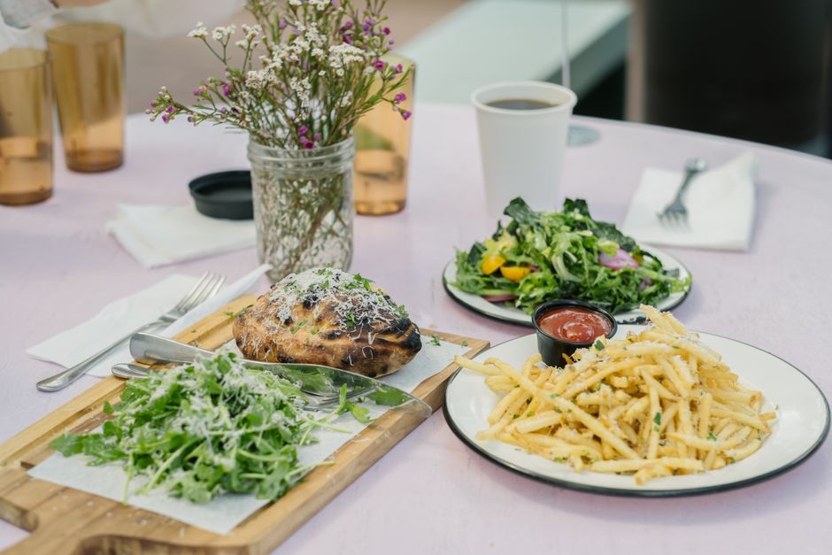 Enjoy a gourmet meal with salad, fries, and bread outdoors on a summer day.