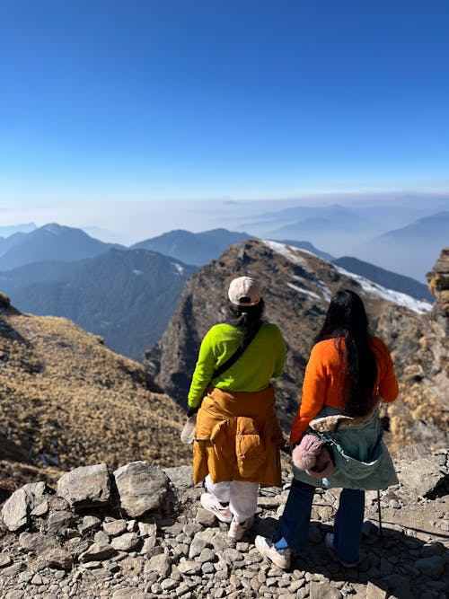 Two women are standing on top of a mountain