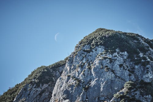 A moon is seen above a mountain