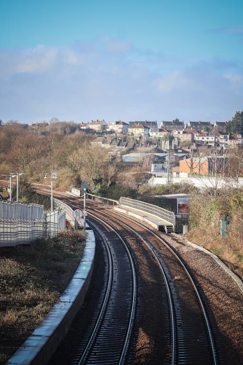 A train tracks running through a city with a view of the sky