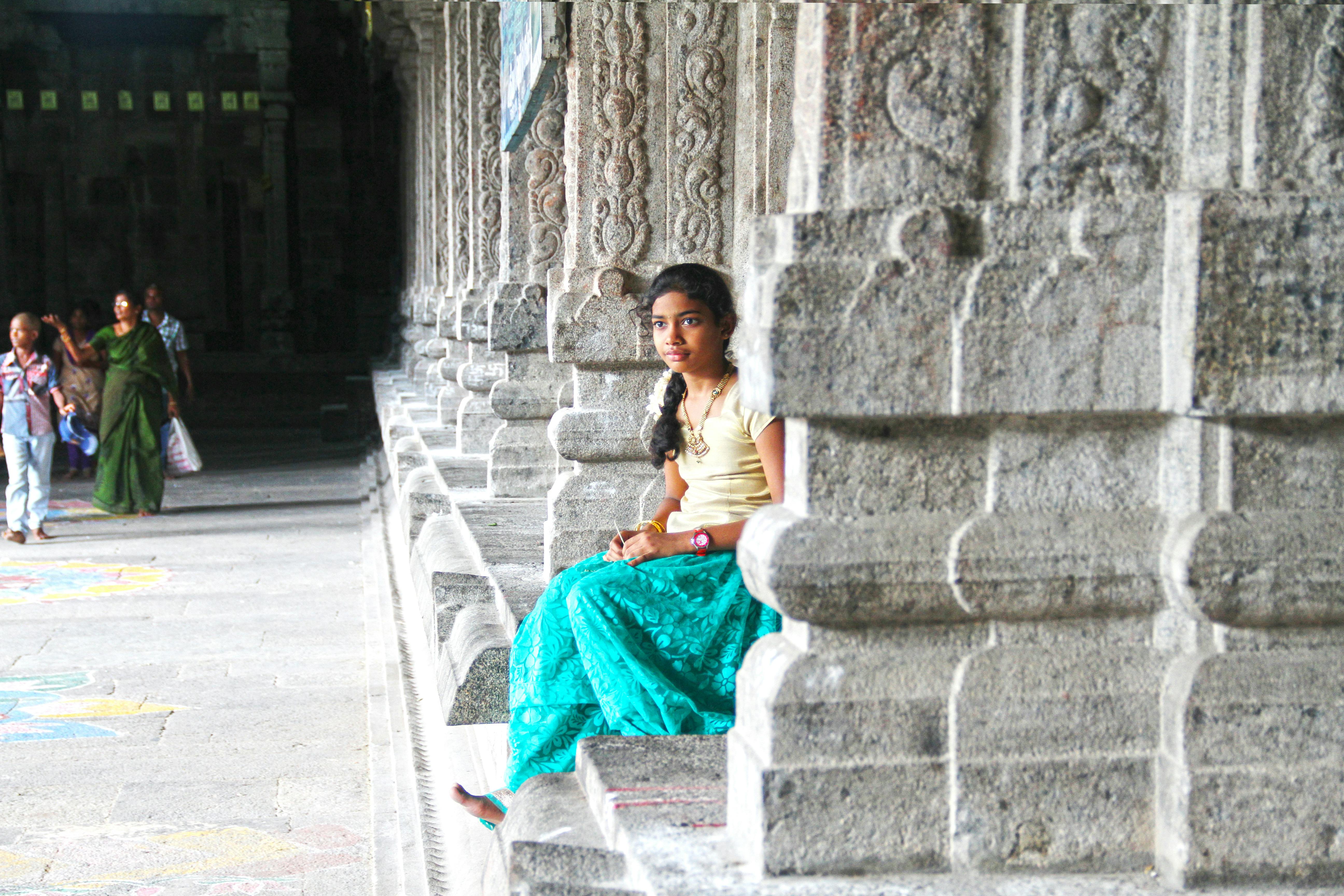 girl sitting near pillars