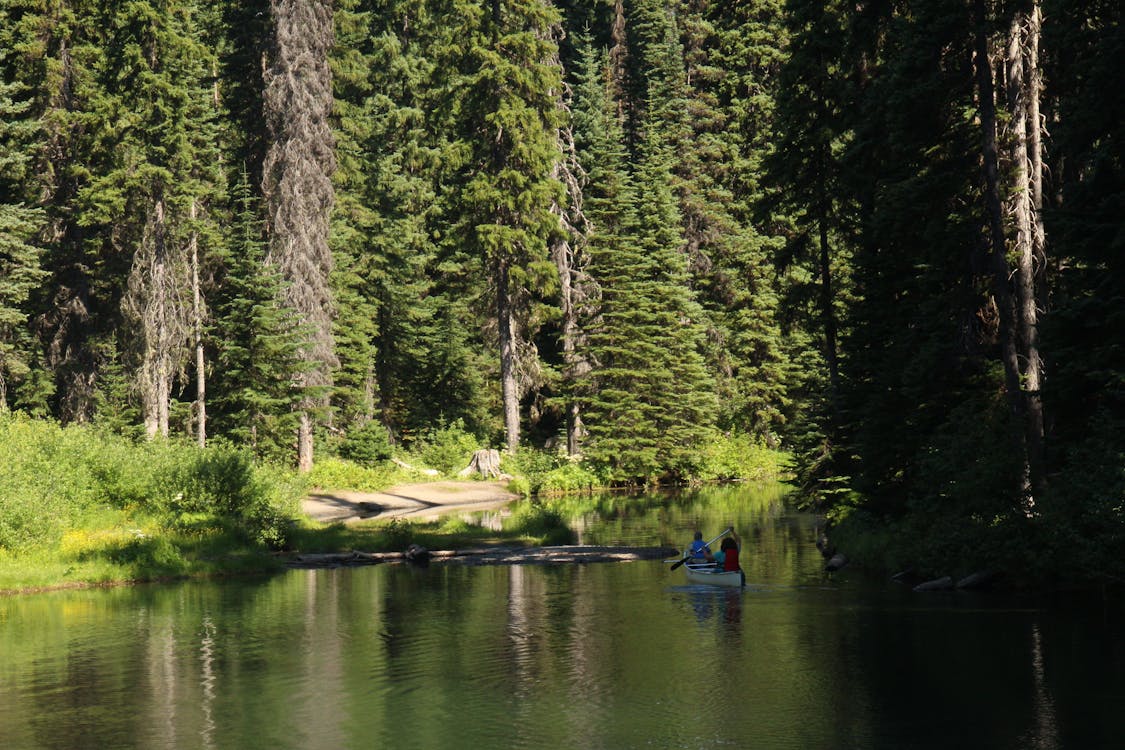 Landscape Photo of Two Person Riding on Blue Boat Surrounded by Body of Water