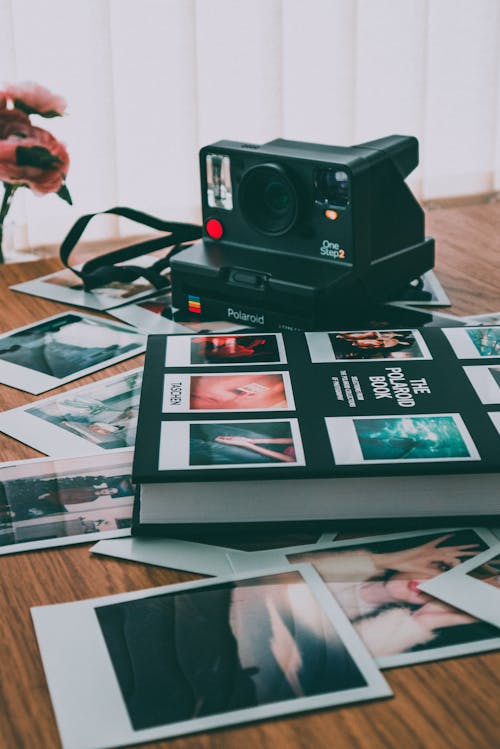 Photo of Polaroid Camera Near Book