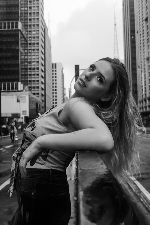 Grayscale Photography of Woman Leaning on Metal Railling