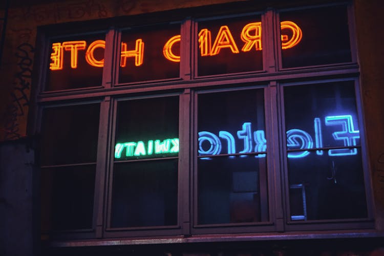 Grey Metal Framed Clear Glass Window With Neon Light Reflection Signage