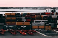 海港一个繁忙的集装箱场，集装箱堆放在黄昏时准备运输