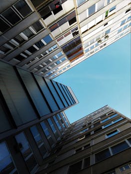 在晴朗的蓝天下，现代摩天大楼呈现出引人注目的向上视角