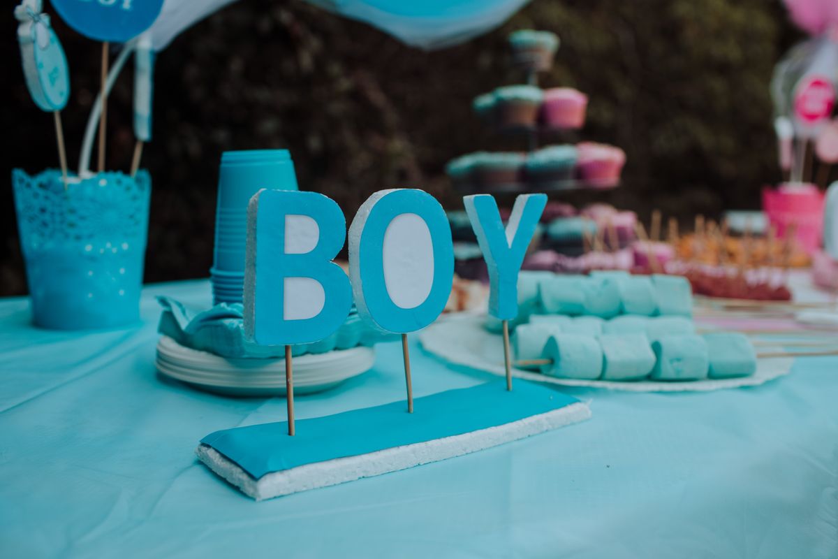 Blue-themed baby gender reveal party with decorations, indicating a boy. Festive atmosphere with sweets and decor. Stock Photo.
