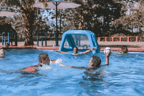 Free People on Swimming Pool Playing Ball Stock Photo