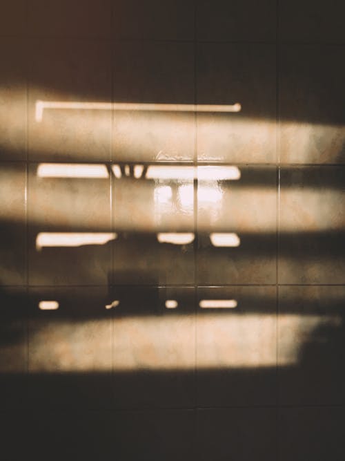 grátis Reflexo Da Luz Solar Passando Pela Janela Na Superfície De Azulejos Marrons Foto profissional