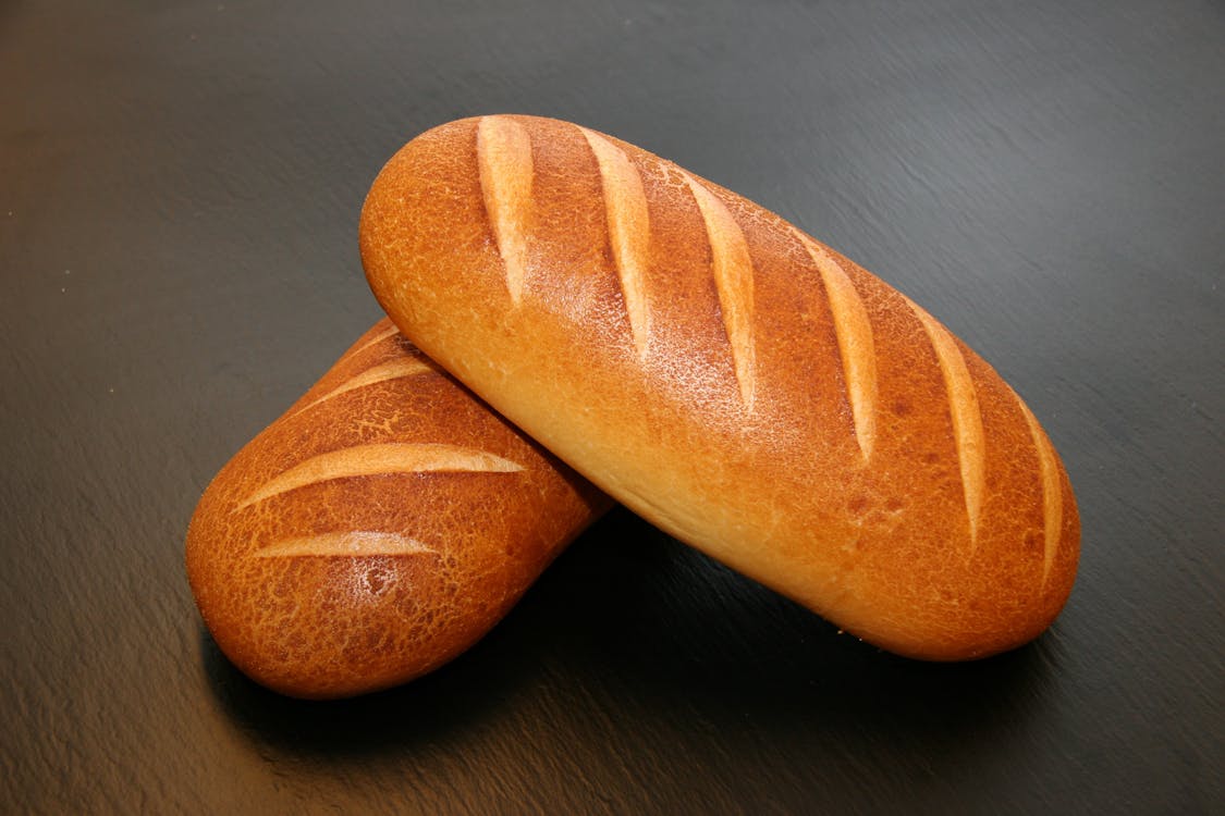 бесплатная Два коричневых хлеба на столе Стоковое фото
