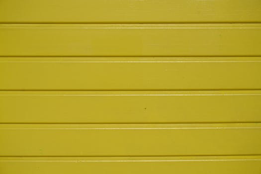 特写镜头下，一面充满活力的黄色木墙与纹理木板相映成趣