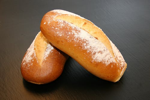 Two Baked Breads on Black Surface