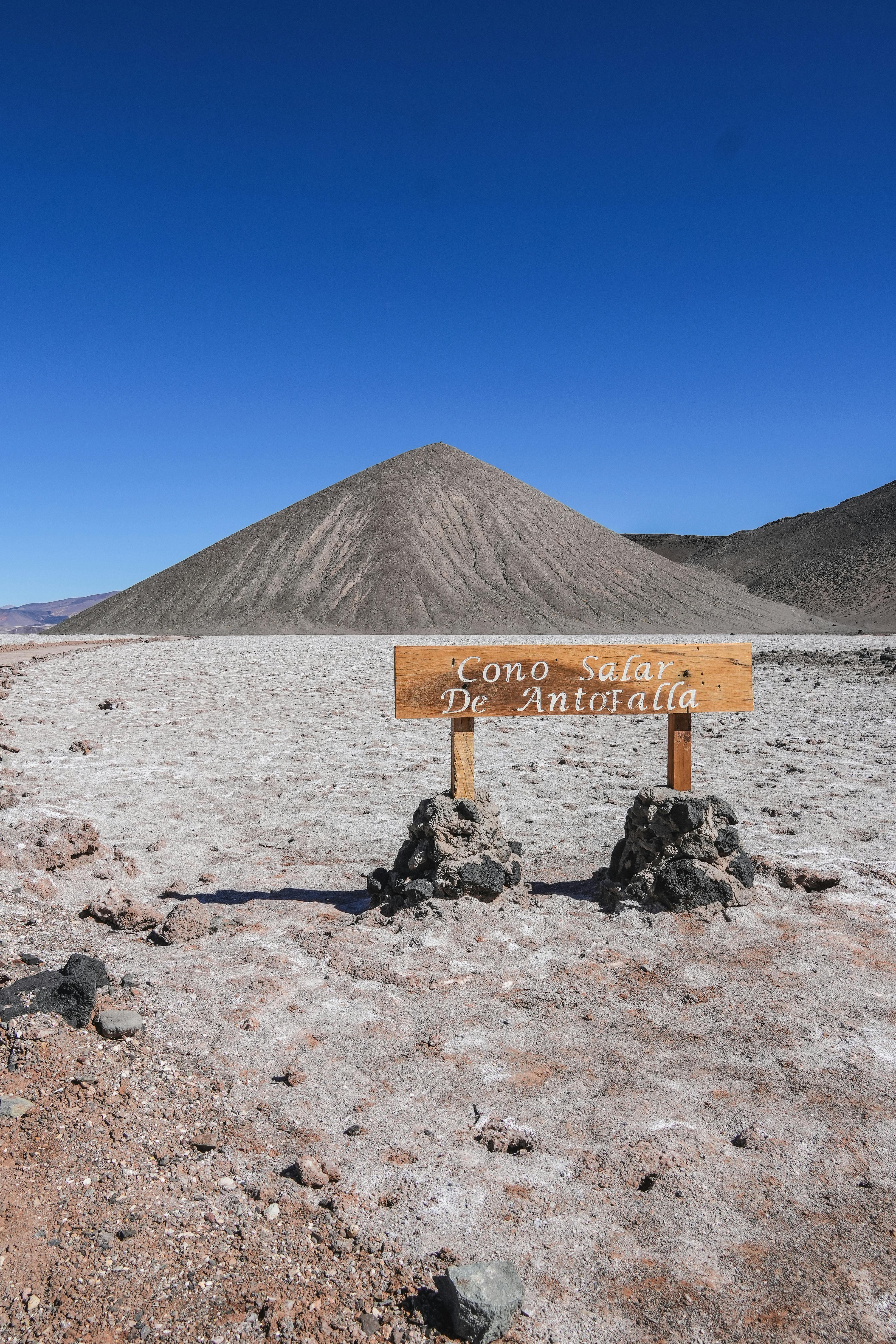 A striking view of the arid Cono Salar de Antofalla, with a sign marking the salt flat.