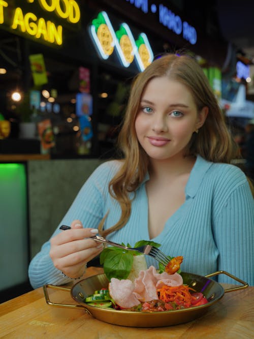 A woman sitting at a table with a bowl of food