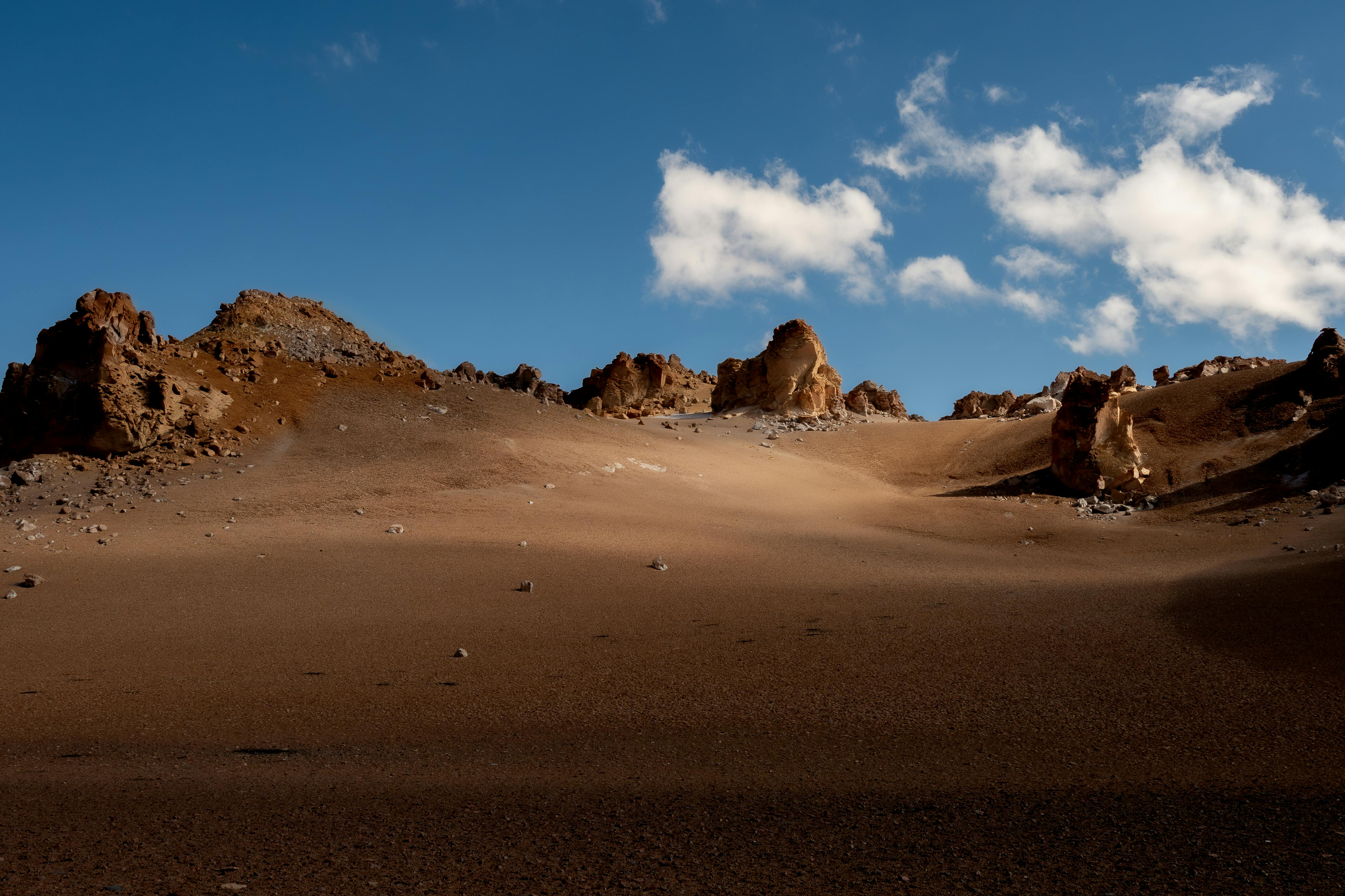 Barren desert landscape in Antofagasta de la Sierra, Argentina, featuring rocky formations under a clear blue sky.