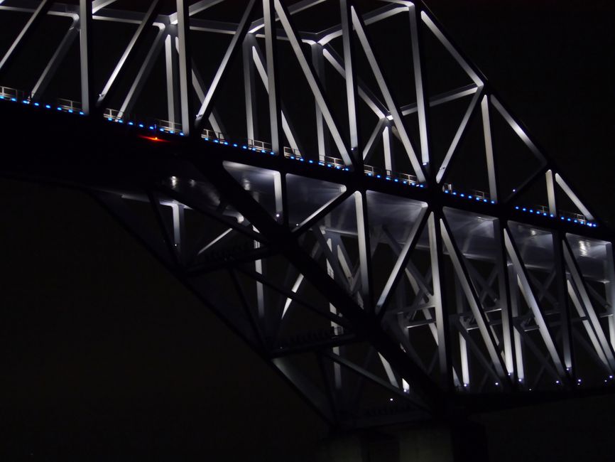 幾何学模様が照らされた現代的な鋼鉄橋の夜景で、都市的および建築的なテーマに最適です。