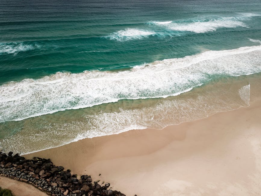 A stunning aerial view of waves crashing on Tallebudgera Beach, QLD, Australia.