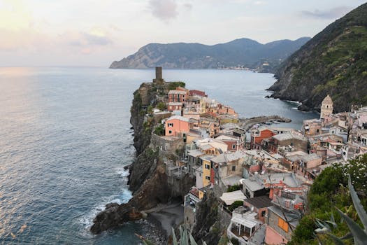 Serene view of Vernazza's colorful buildings on the rugged Italian coast during dusk.