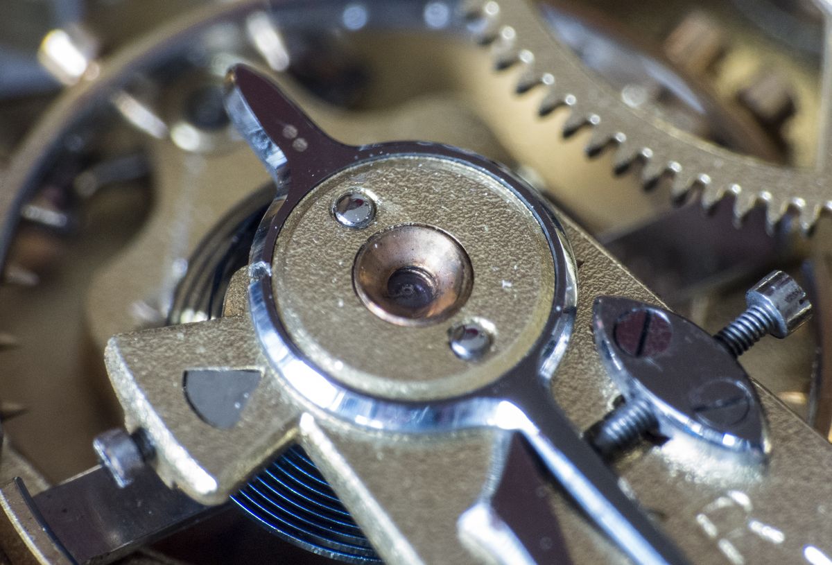Macro view of the gilt wheels and balance of a mechanical watch movement — photo by Pixabay on Pexels