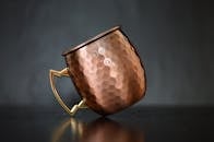 特写一个带有金属手柄、经过锤击工艺完成的豪华铜杯