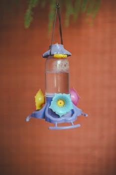 在模糊背景的映衬下，悬挂喂鸟器充满活力，点缀着花卉图案