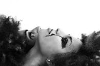 一张黑白艺术照片中的女人，以表现主义妆容传达情感