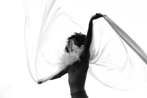 Grayscale Photography of Man Swishing Mesh Veil